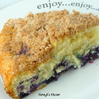 A slice of blueberry crumb cake on a white plate.
