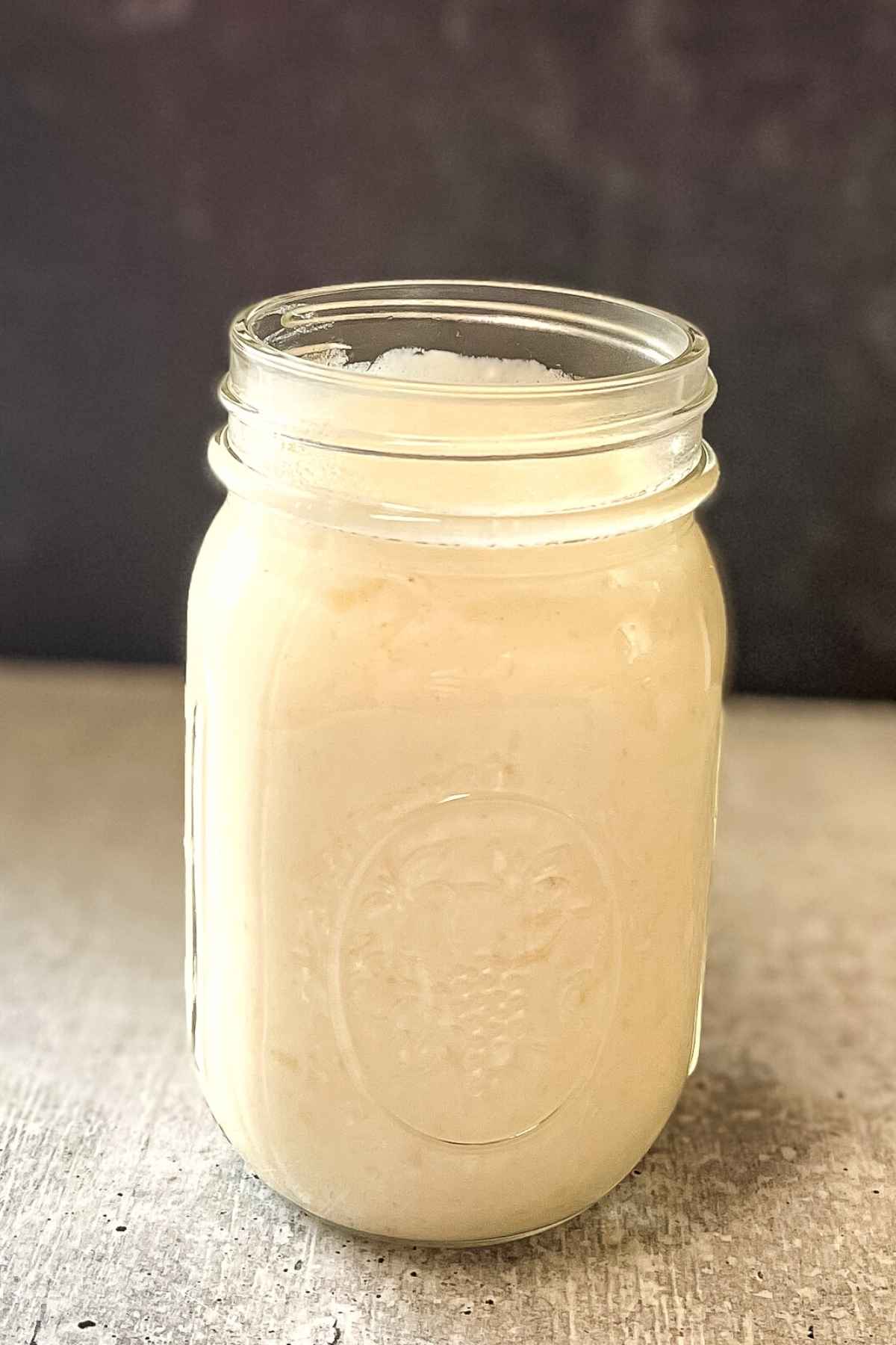 A mason jar full of easy homemade alfredo sauce.