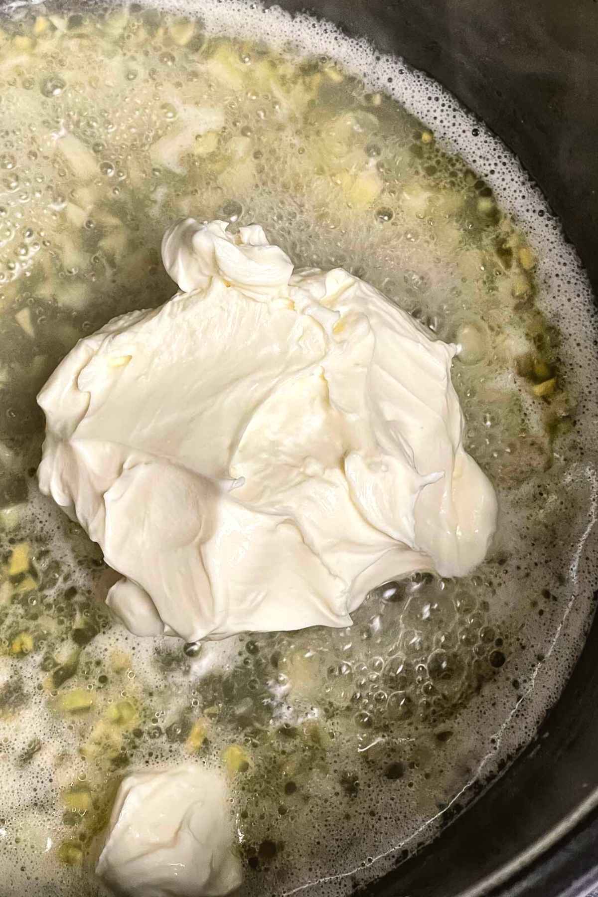 Adding cream cheese to the garlic mixture.