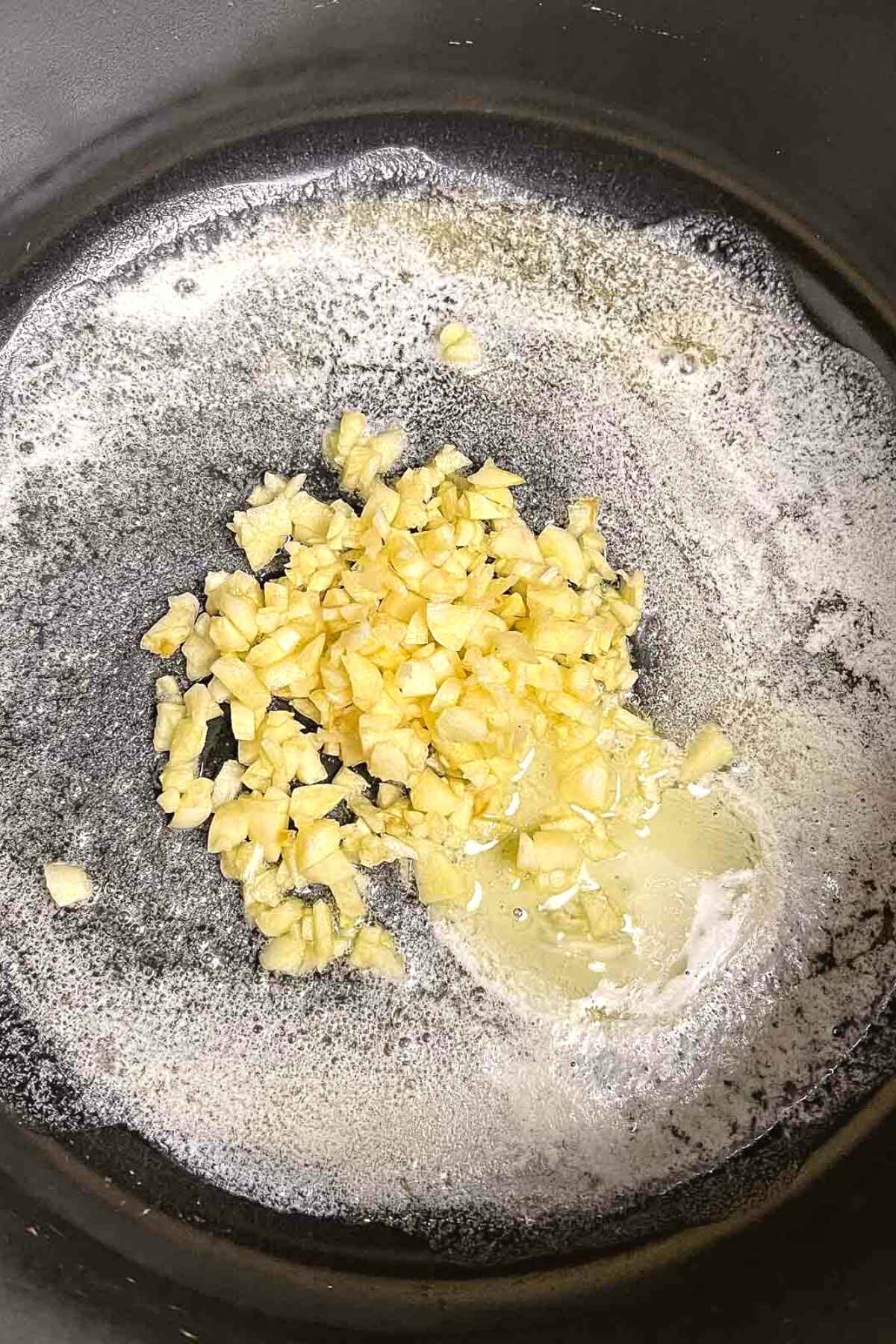 Bubbly butter with fresh chopped garlic in a saucepan