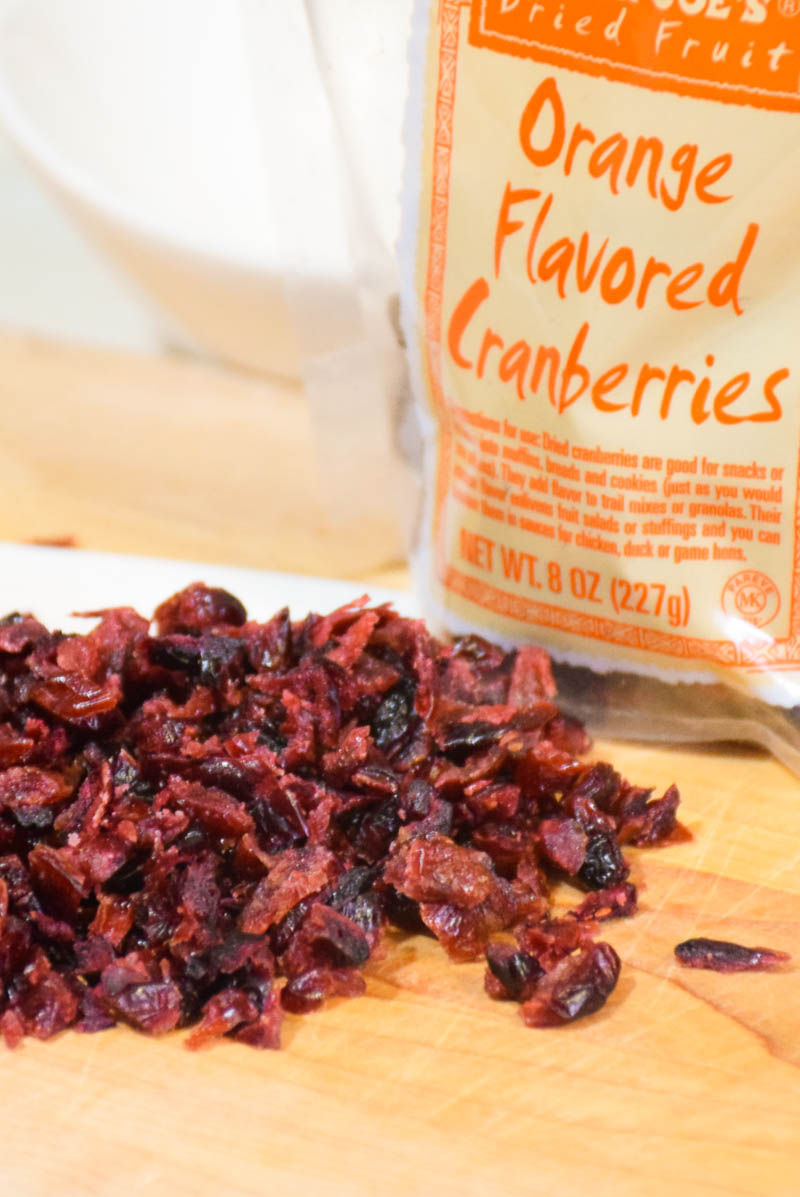 Orange flavored cranberries on a wooden board.