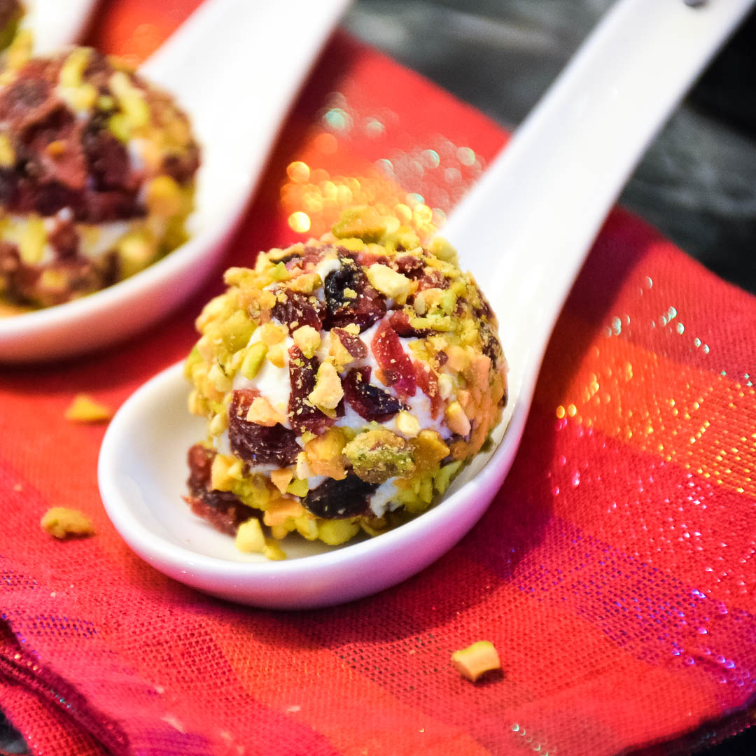 Up close image of a festive cheese ball on a tasting spoon.