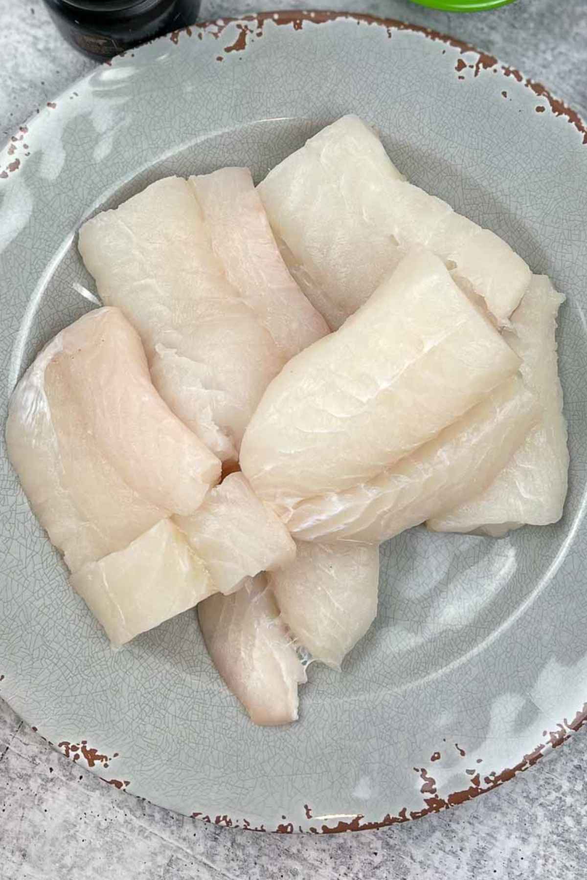 A plate with fresh cod fish.