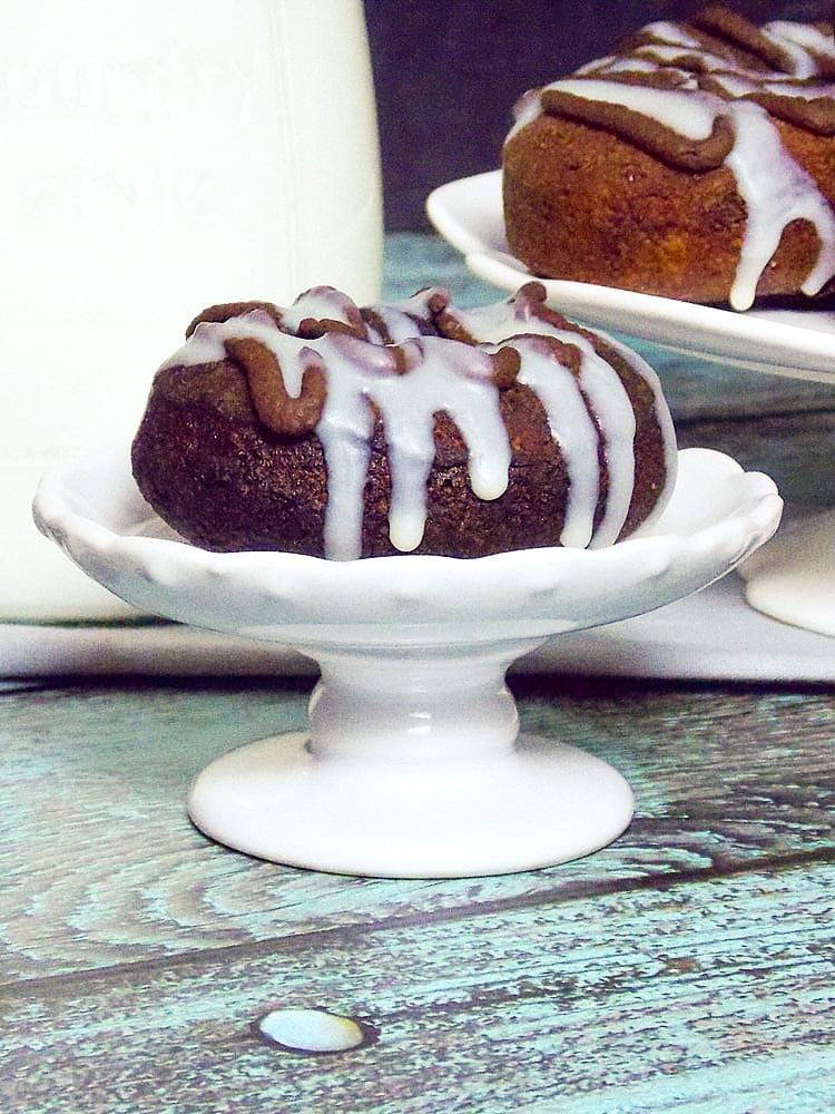 A single chocolate doughnut on a serving pedestal.