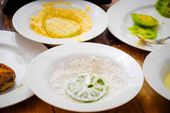 Bowls with flour, cornmeal, buttermilk mixture for assembly line.