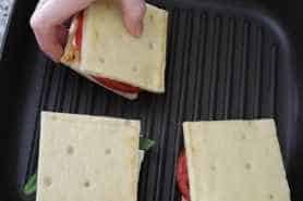 Placing a sandwich on the grill pan.