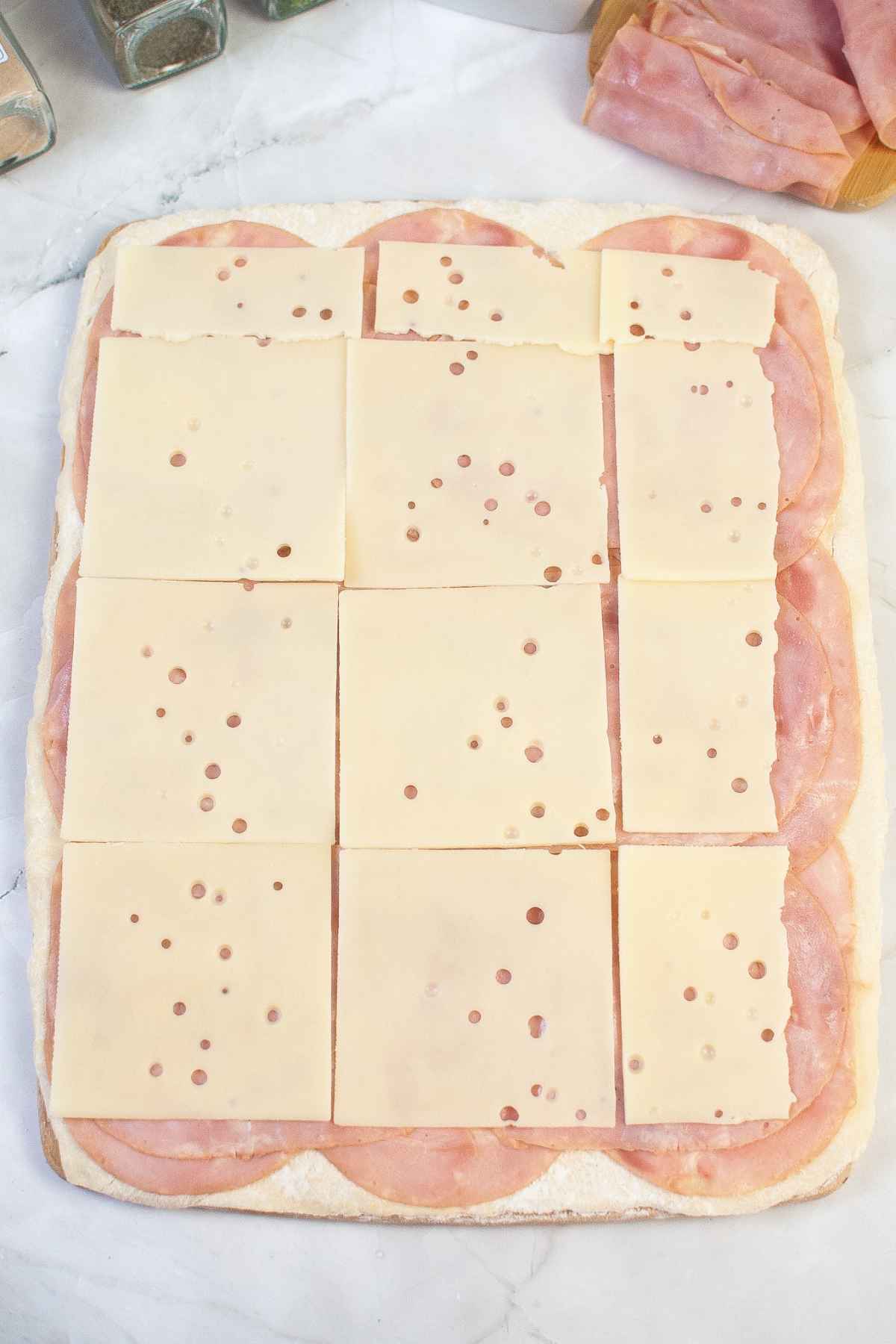 Layers of ham and cheese on pastry dough.