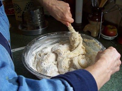 Hand mixing the remaining flour into dough.