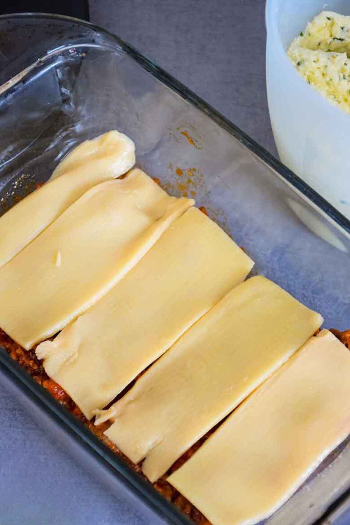 Image of meat layer with hearts of palm sheets over top of meat in a loaf pan.