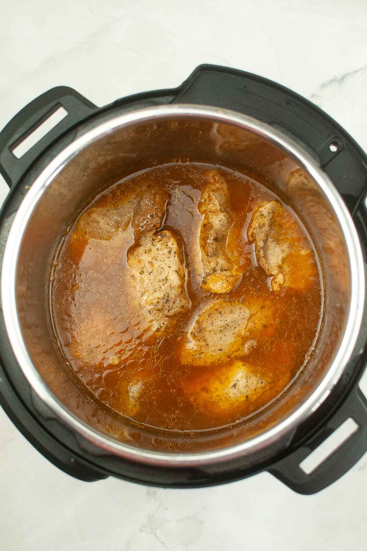 Cooked ribs in the cooking broth in an instant pot.
