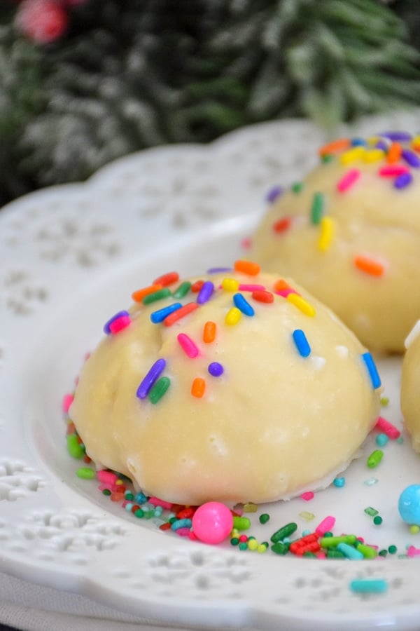 Italian Christmas Cookies with Almond Glaze and Sprinkles on a white plate.