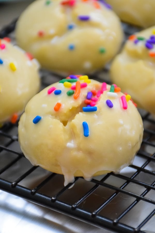 Glazed cookies on cooling rack with colored jimmies on top