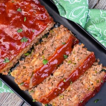 Overhead image of jalapeno meatloaf cut into slices on a black tray.