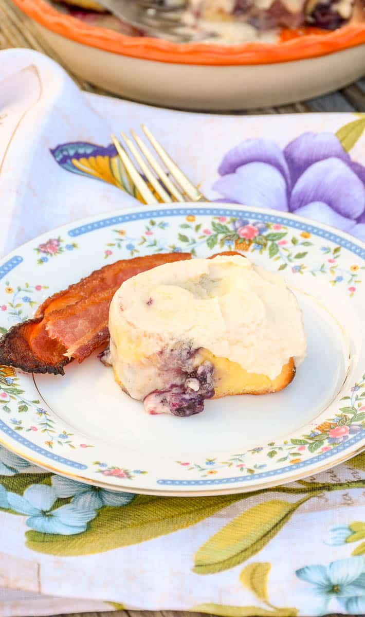 Keto Blueberry Sweet Rolls on a plate with a side of bacon.