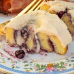 Keto blueberry sweet roll that has been cut in half so you can see the blueberry filling.