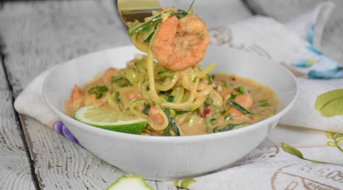 A piece of shrimp and zoodles on a fork.