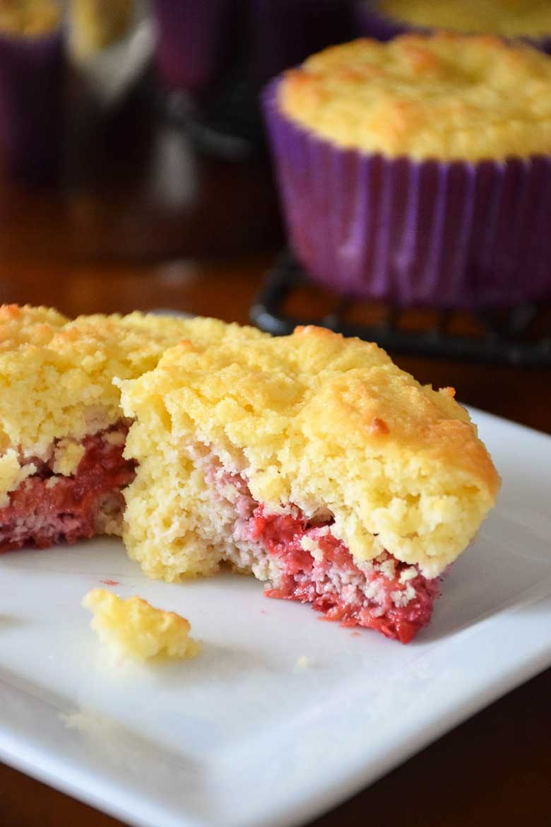 Keto Raspberry Muffins cut in half and on a plate.