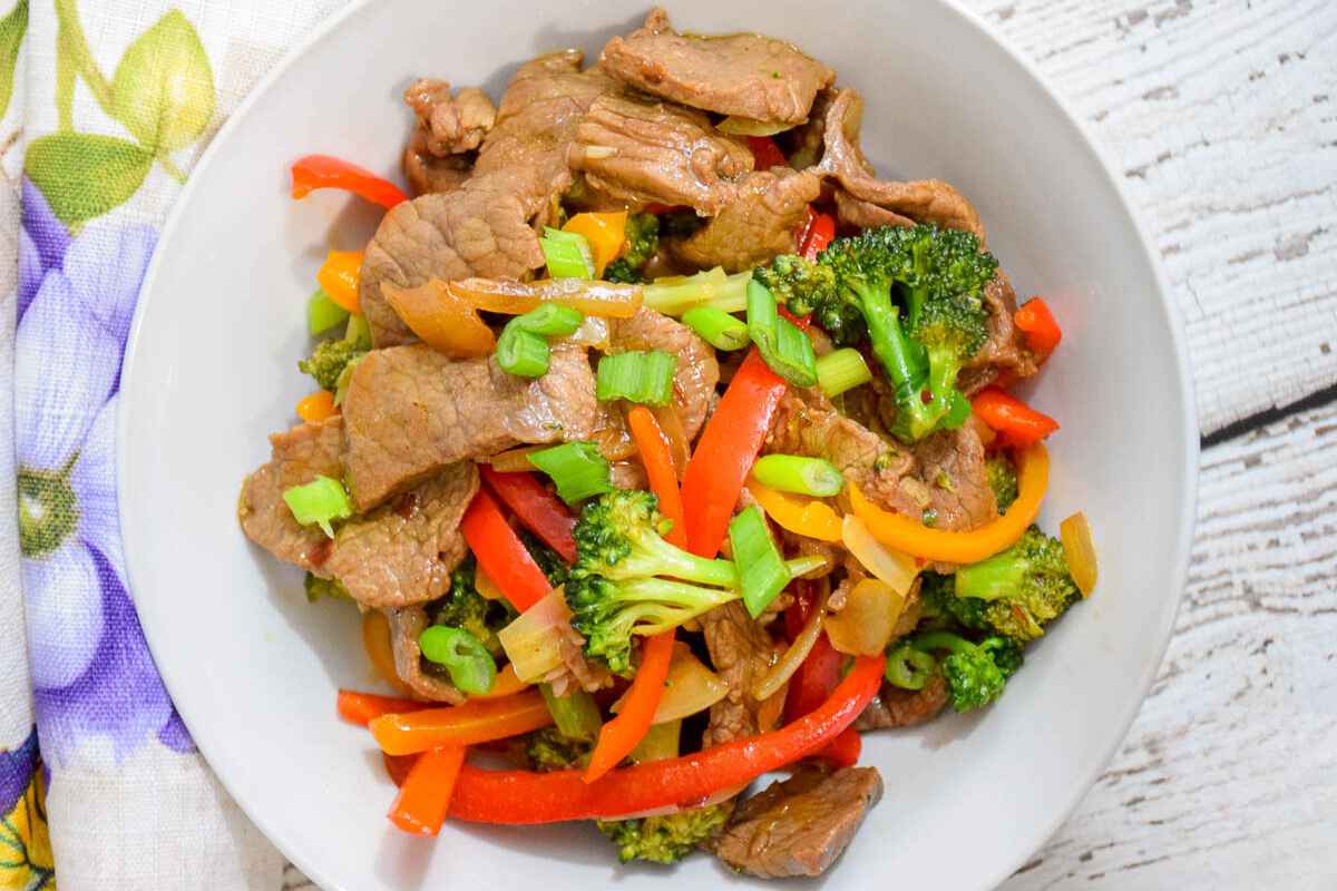 Overhead image of low carb beef stir fry in a white bowl.