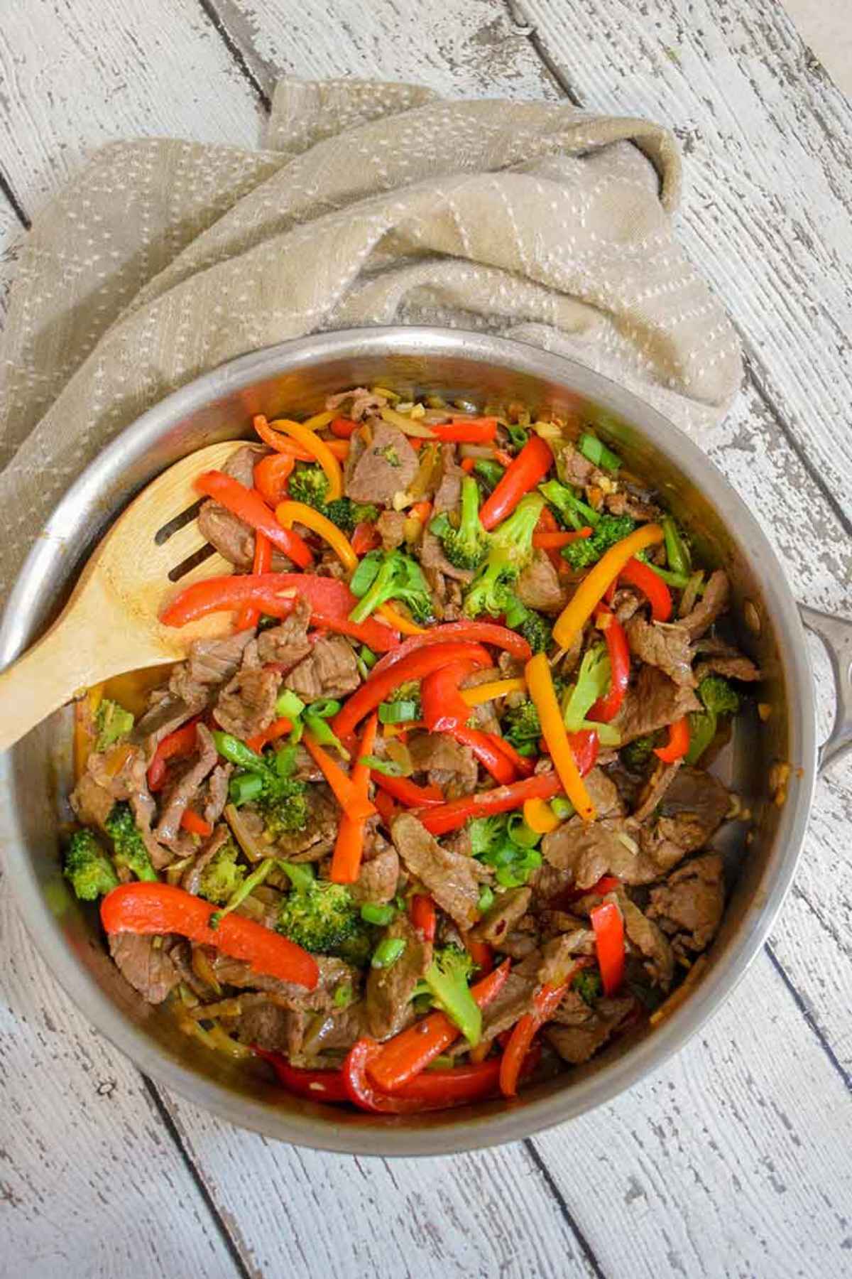 Stainless steel skillet filled with low carb beef stir fry made with beef strips, bell peppers, and broccoli.