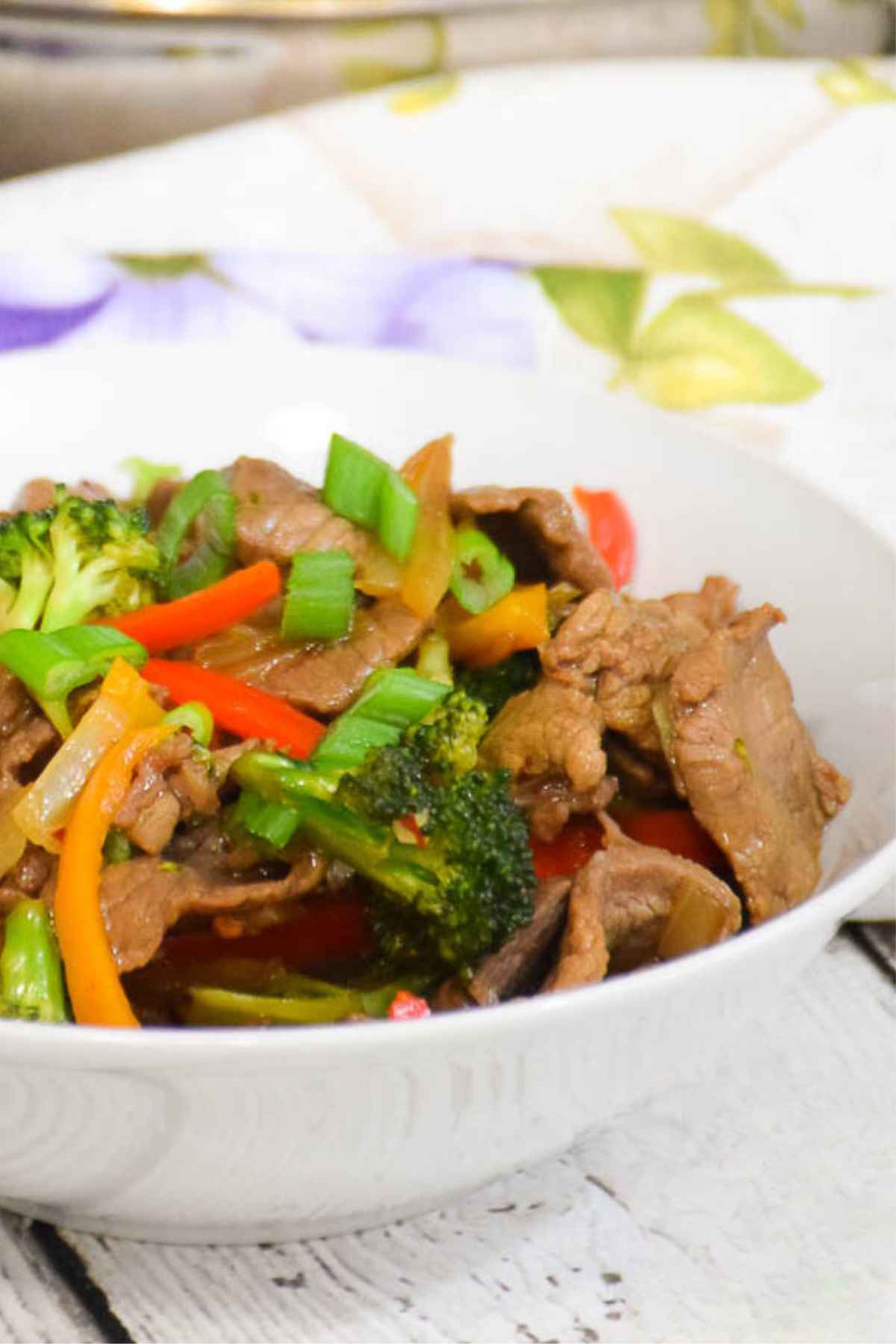 Side view of a bowl of beef and broccoli stir fry.