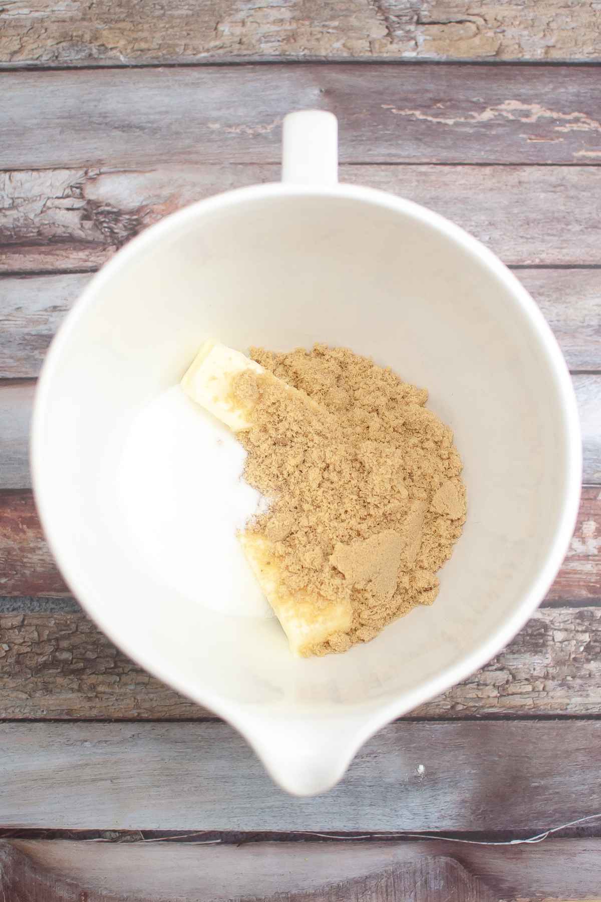Brown sugar, white sugar, and butter in a white mixing bowl.