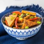 Featured image for pan fried tofu in a blue and white bowl.