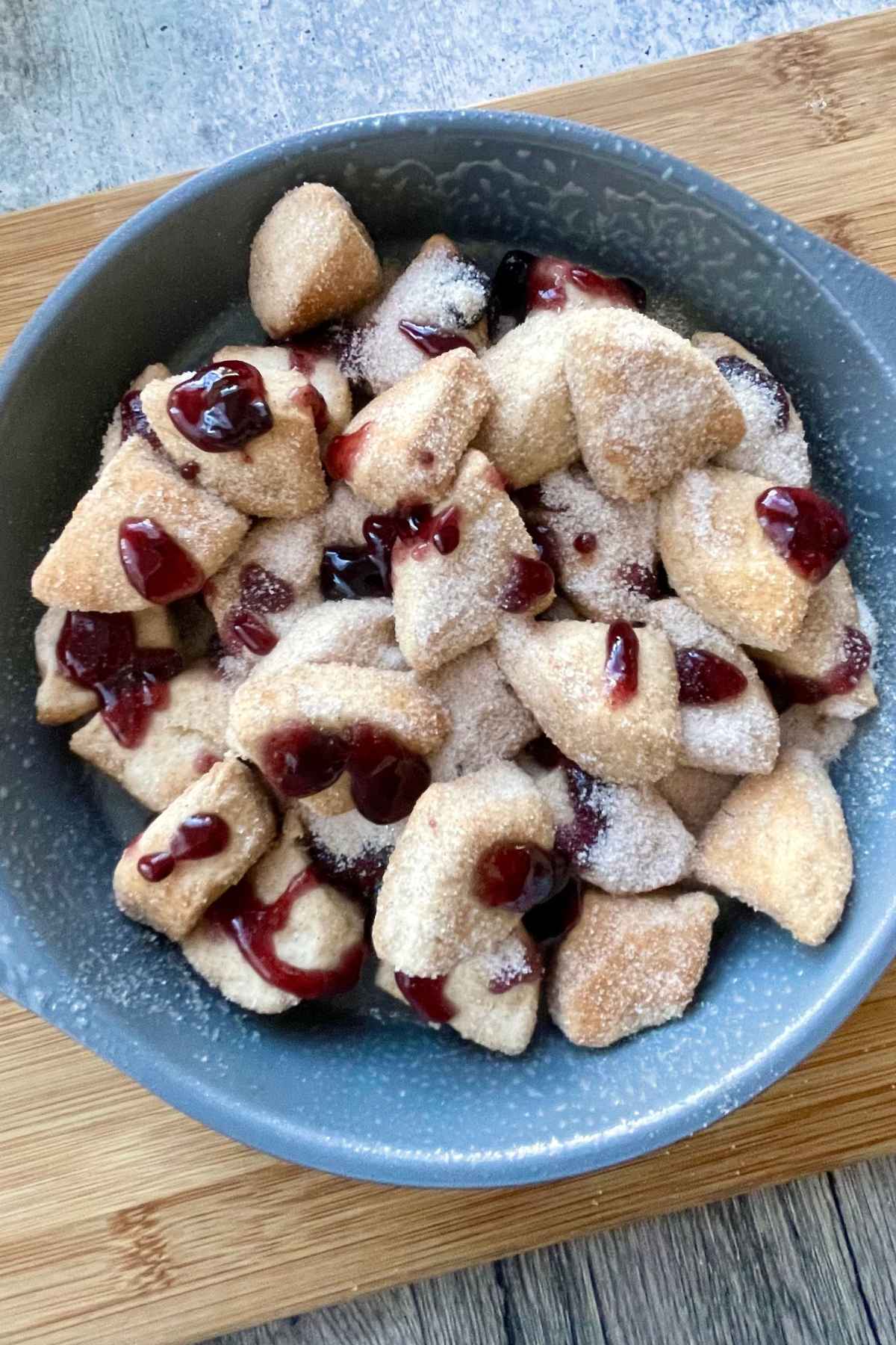 Unbaked biscuit dough coated in cinnamon sugar with jam drizzles.