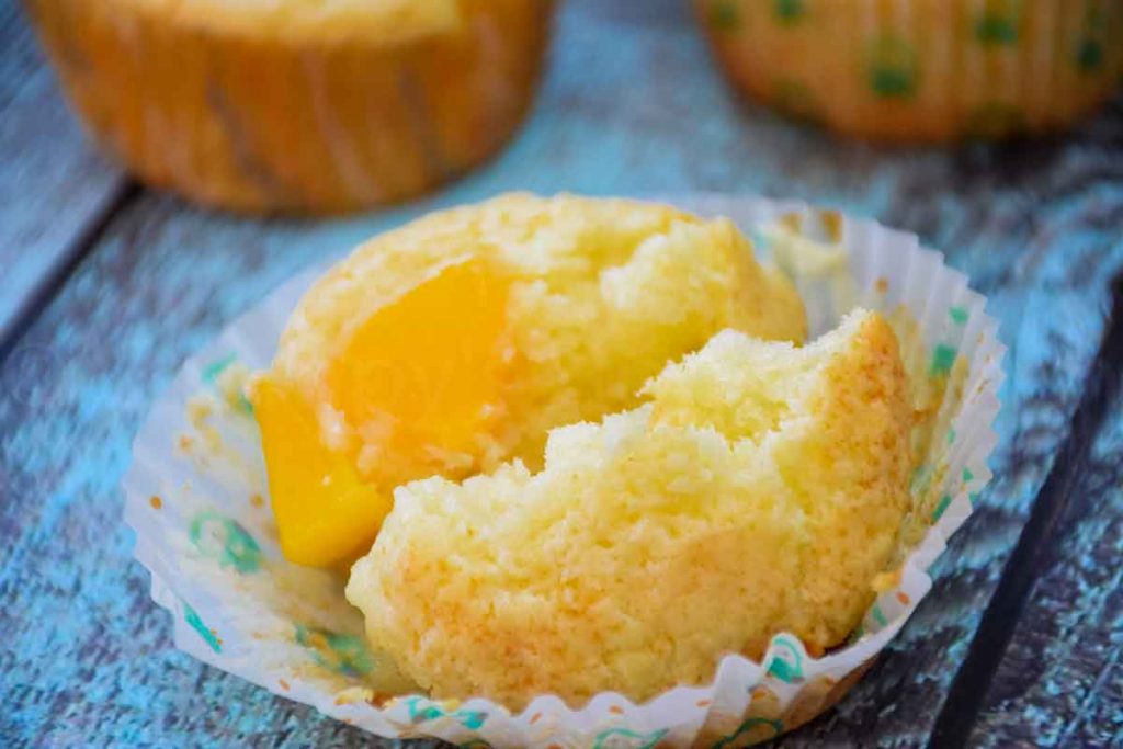 Peach muffin broken in half to show the inside of the muffin