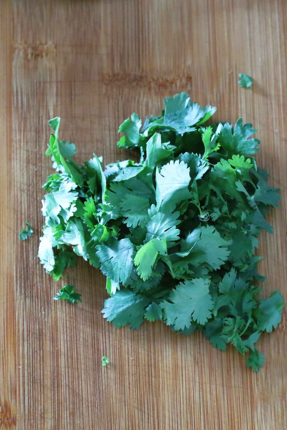 Fresh cilantro leaves on cutting board.