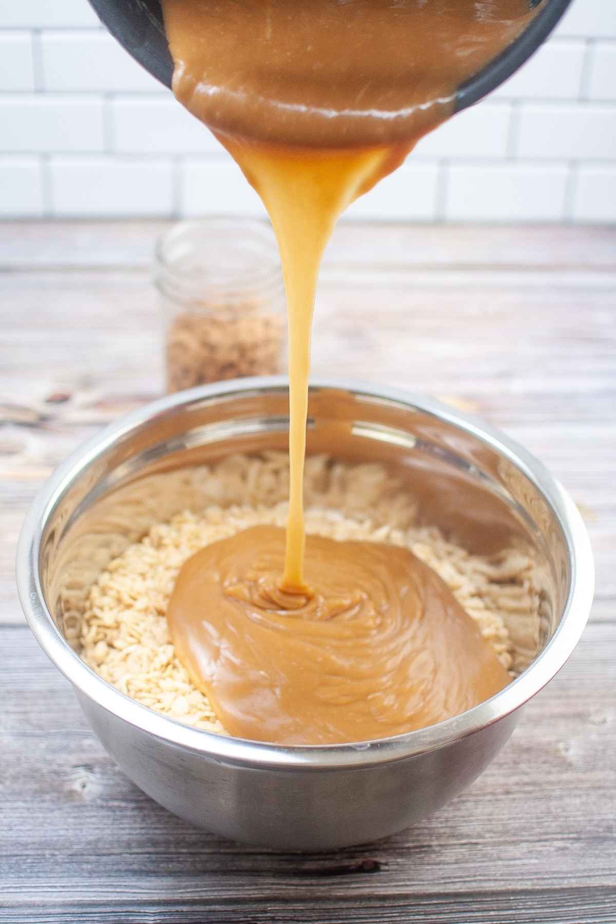 Pouring the peanut butter mixture over top of the dry ingredients.