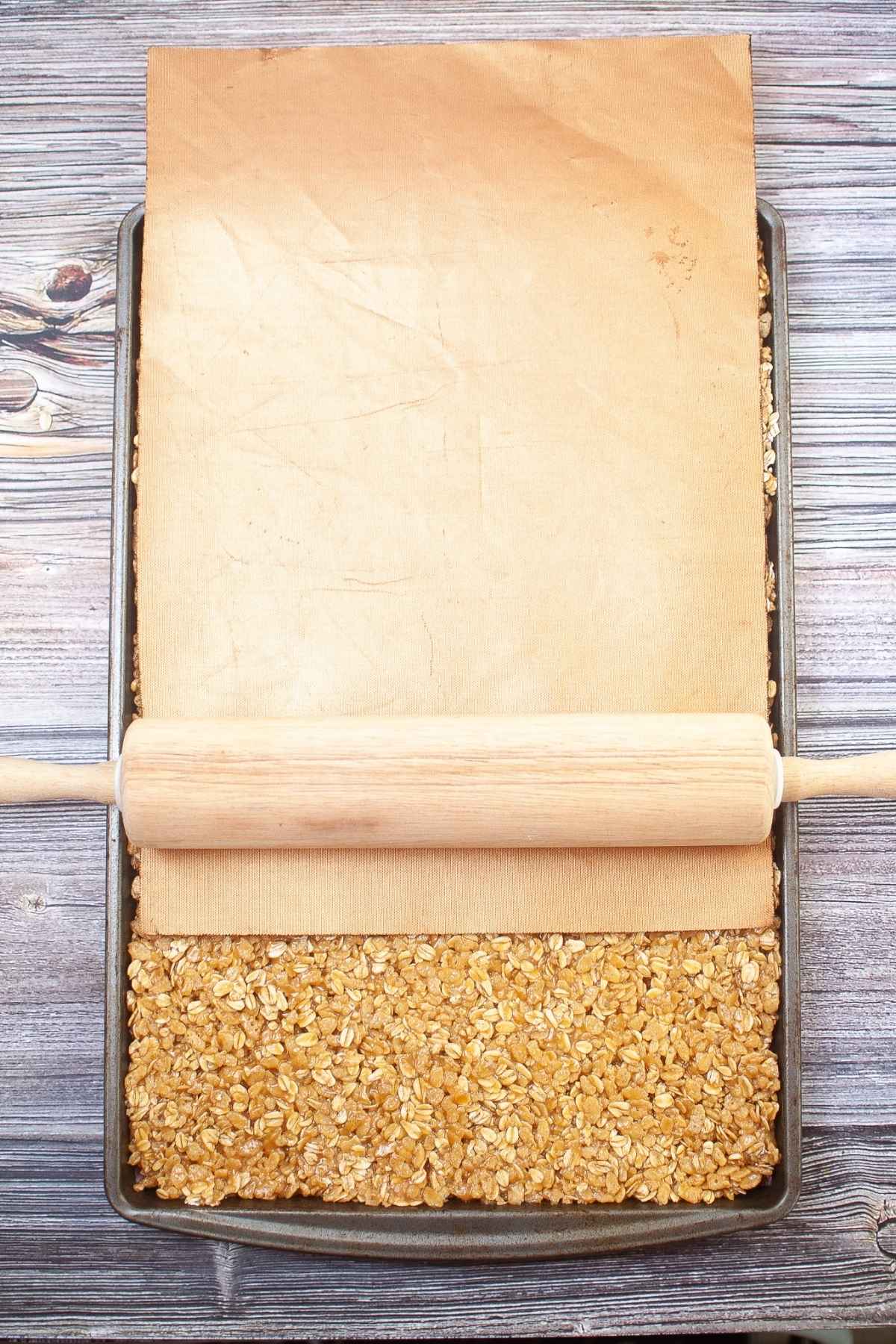 Rolling pin with parchment paper on bars.