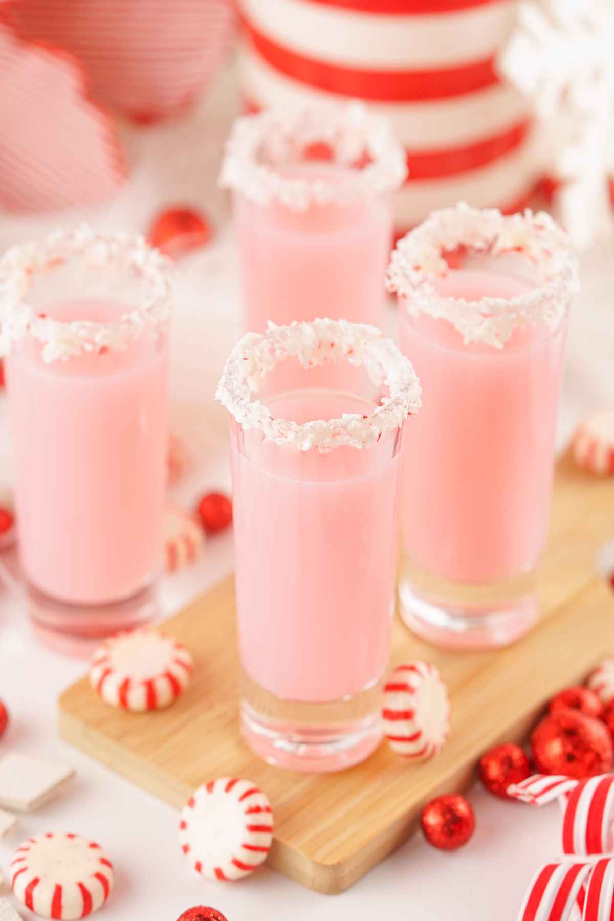 Peppermint vodka in shot glasses rimmed with crushed peppermint candies.