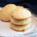 Three pineapple cookies stacked on a plate with a floral rim.