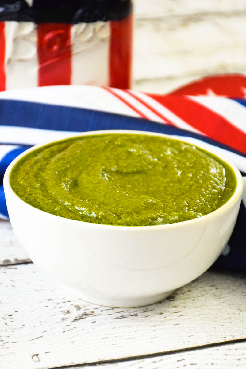 A white bowl full of pistachio pesto.