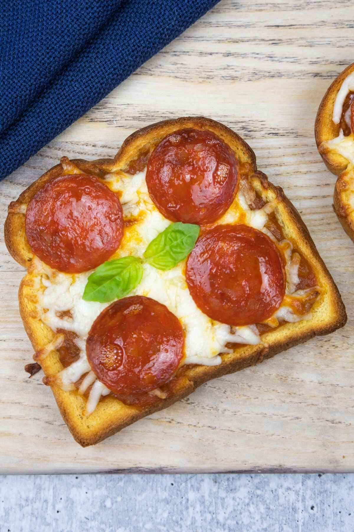 One slice of pizza toast with melty cheese and golden brown edges.