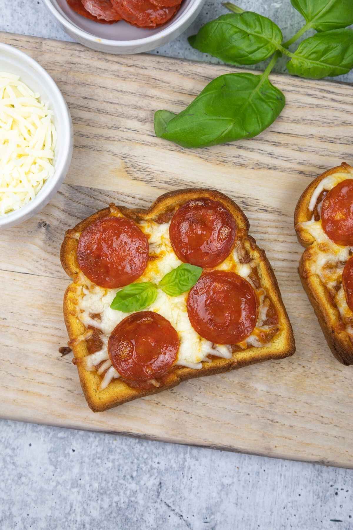 Overhead image of pizza toast with melted cheese and golden brown edges.