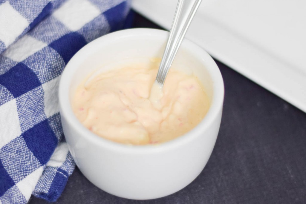 Remoulade sauce in a white bowl with a spoon.