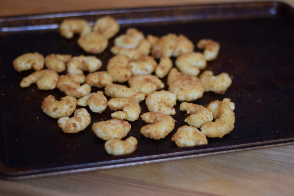 Frozen breaded popcorn shrimp on a baking tray
