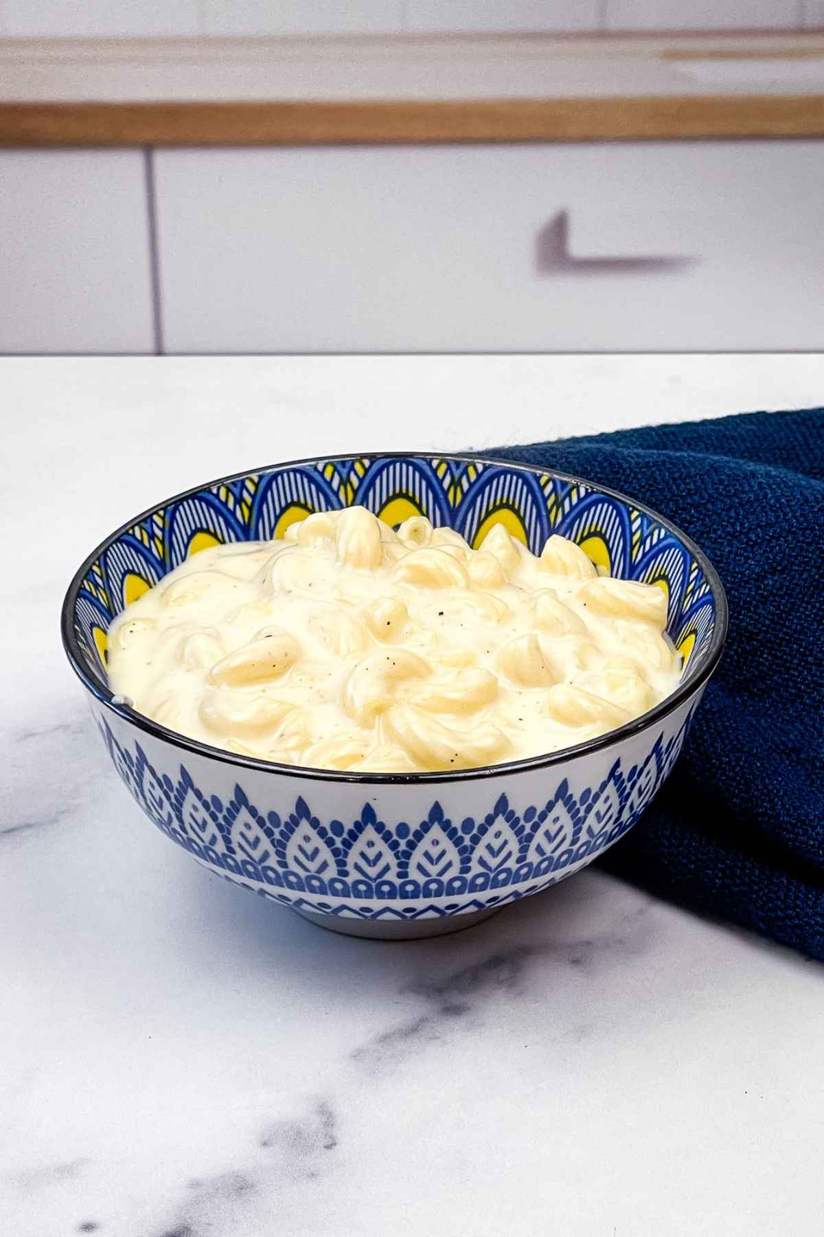 Creamy stovetop macaroni and cheese in a blue bowl.