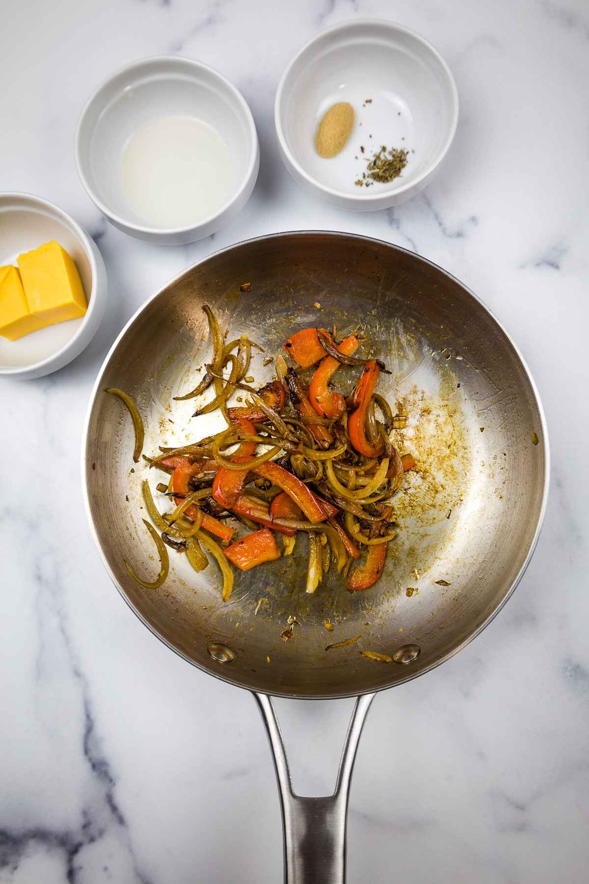 Peppers and onions cooked in a skillet.