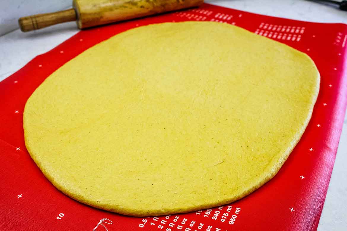 Pumpkin dough rolled out onto a mat.