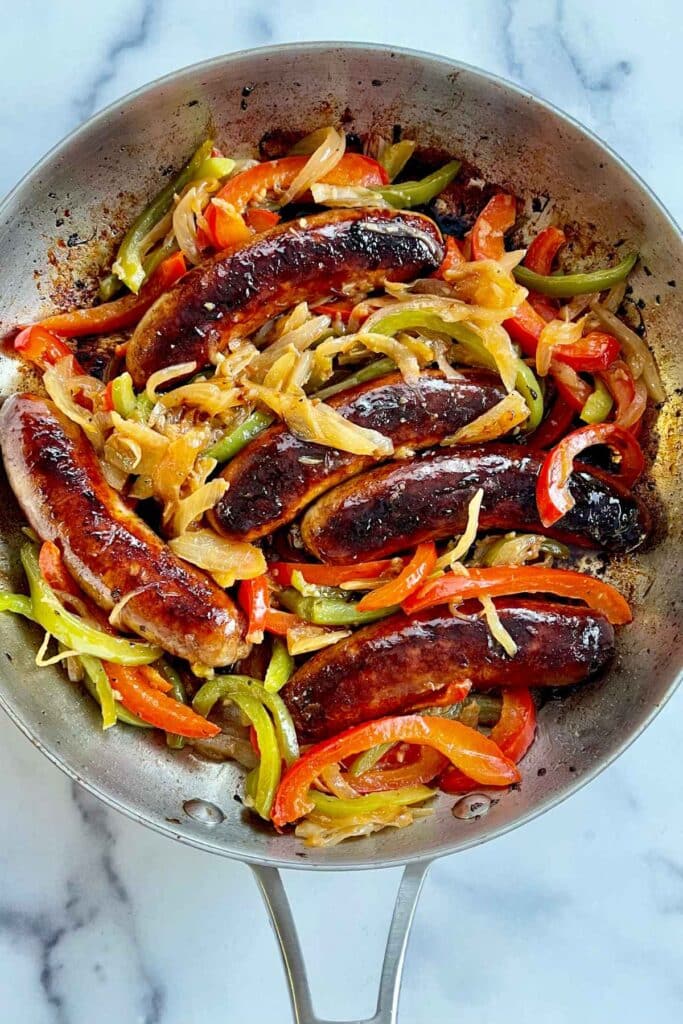 Cooked Italian Sausages with Peppers and Onions in a large skillet.