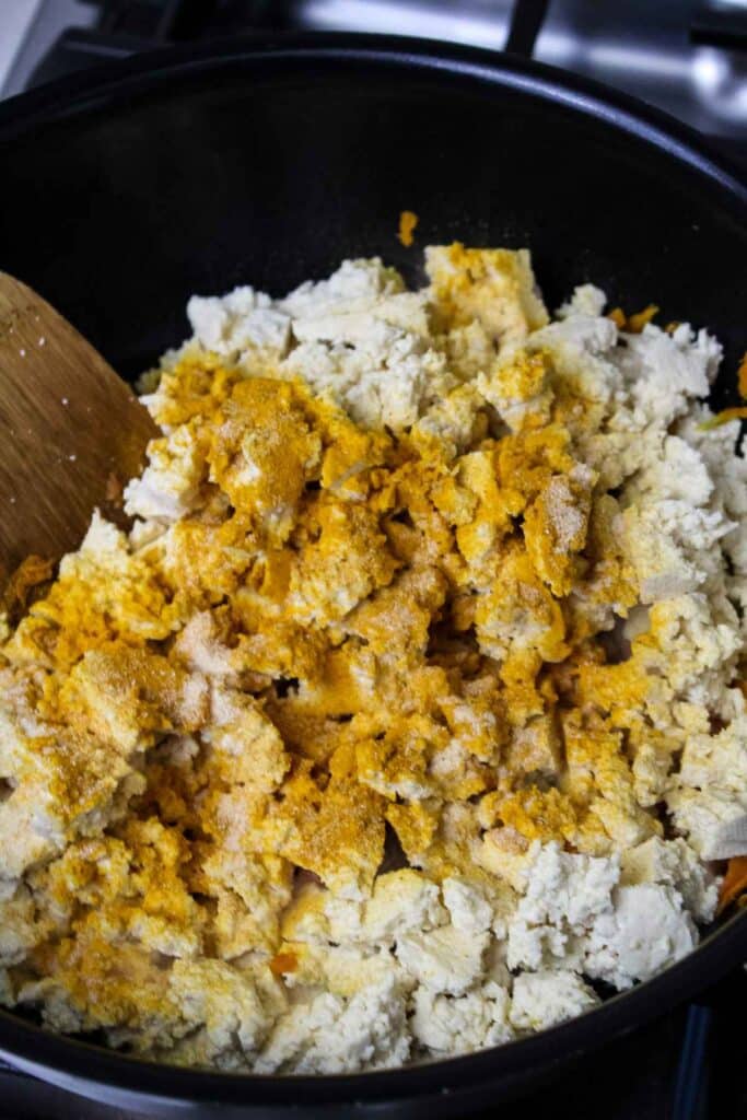 Crumbled tofu in a skillet with seasonings on top.