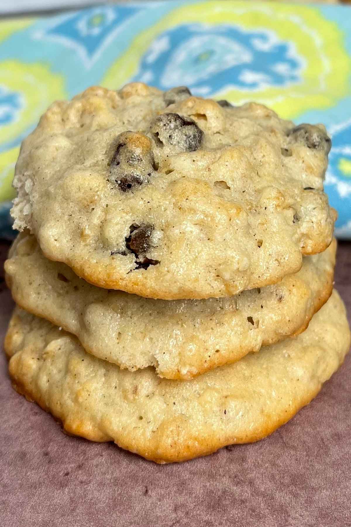 A stack of 3 soft oatmeal cookies studded with raisins.