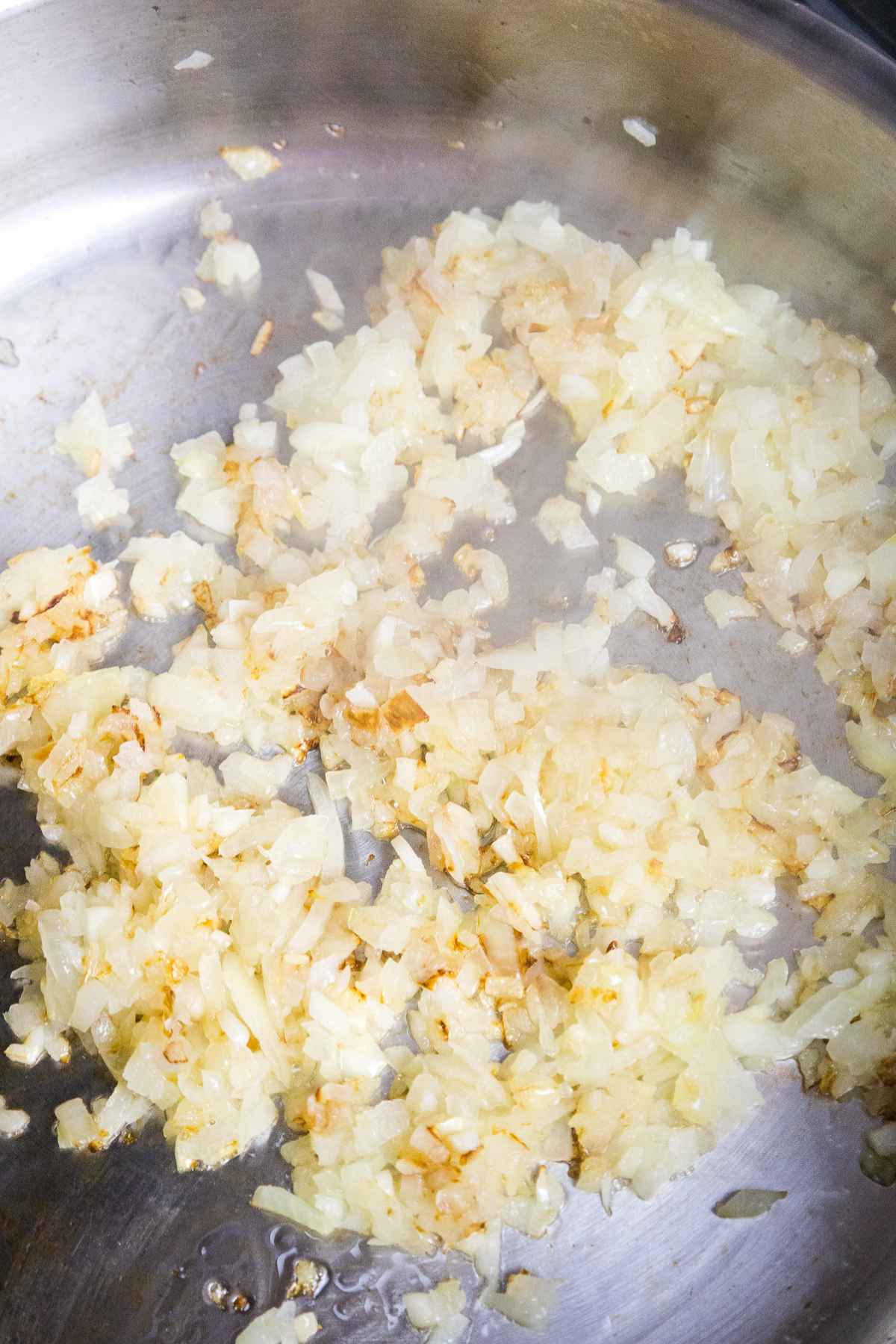 Sauteed onion and garlic with bits of browned onion in a skillet.