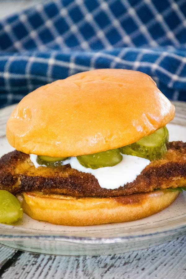 Crispy Chicken Sandwich with blue cheese sauce and pickles on a toasted bun.