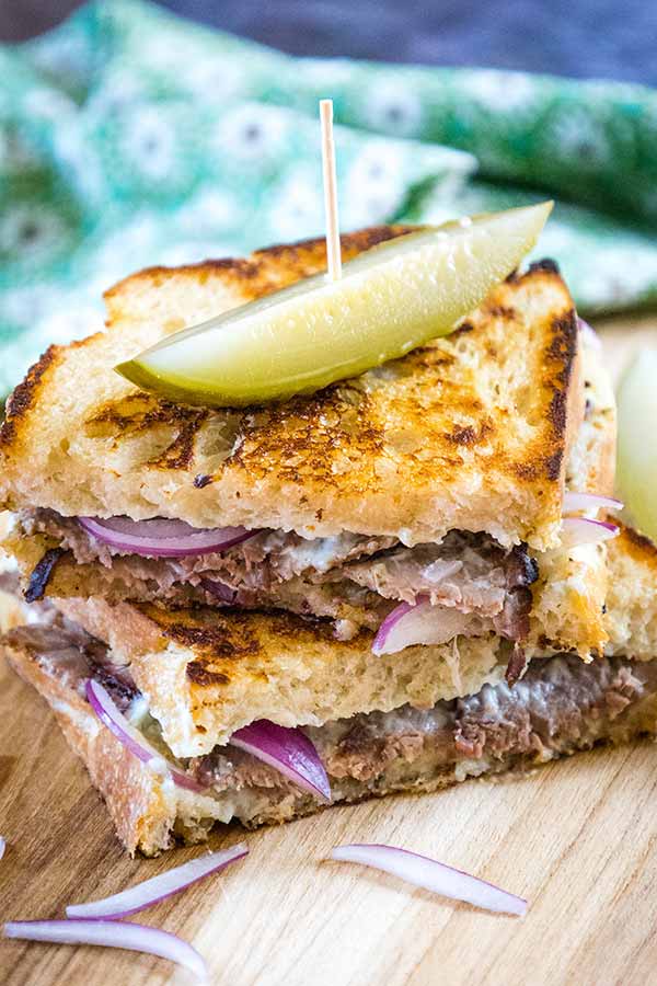 Grilled Steak Sandwich with Blue Cheese Spread, red onion slices, and a dill pickle spear