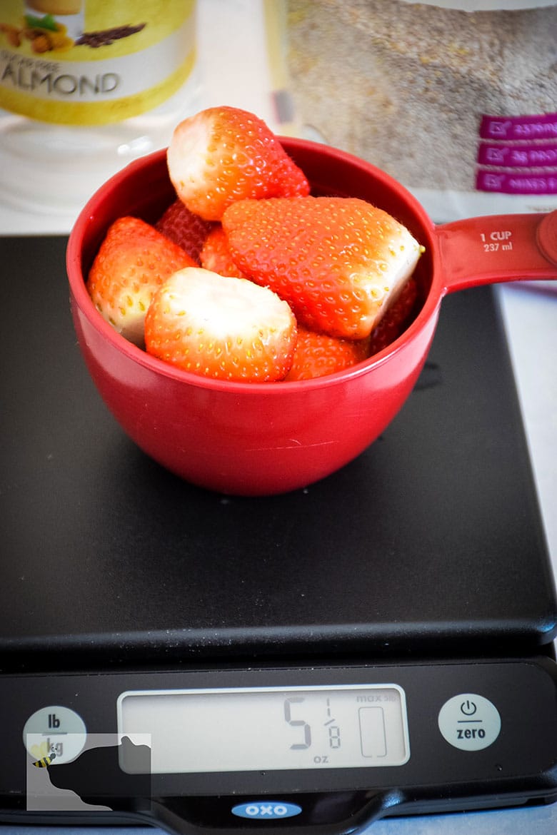 Measuring cup full of strawberries.