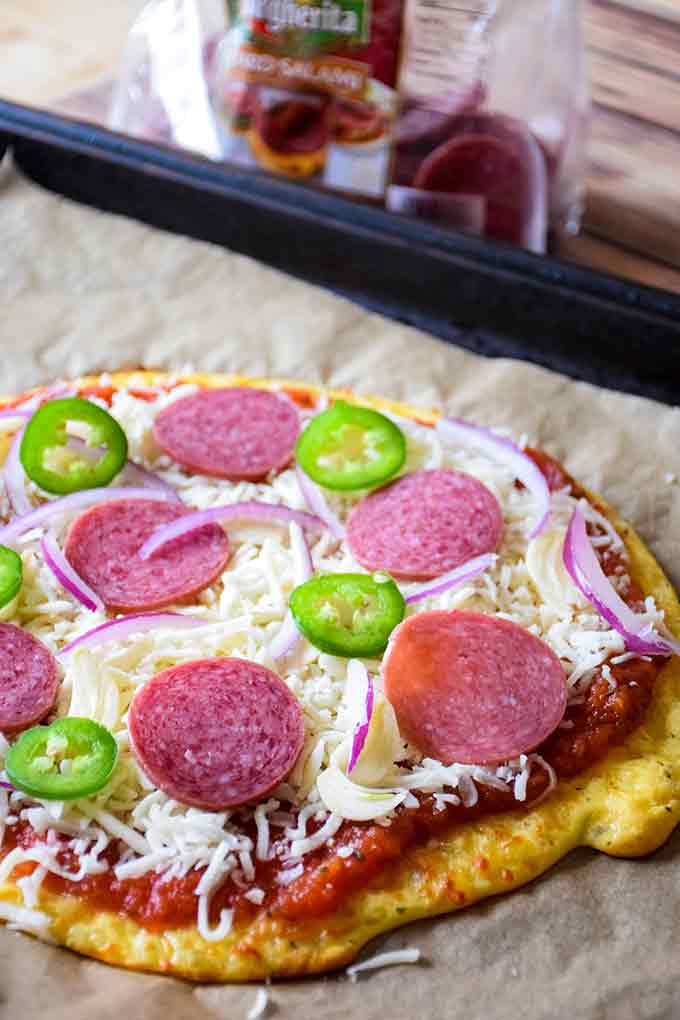 Dressed keto salami pizza before the final baking.