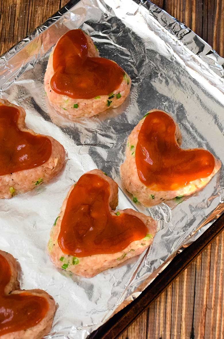 Mini Heart Shaped Veal Meatloaf on the baking sheet ready to go in the oven.